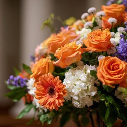 Orange roses and white flowers representing cremation services in Dayton, WA.