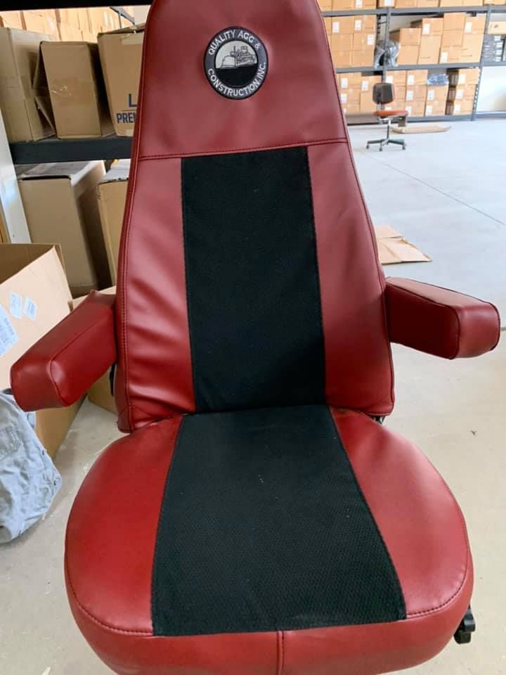 Red reclining office chair with black center panel and arms in a warehouse setting