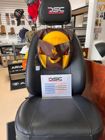 Black DSC car seat with a yellow helmet-like object and product sign in a store aisle