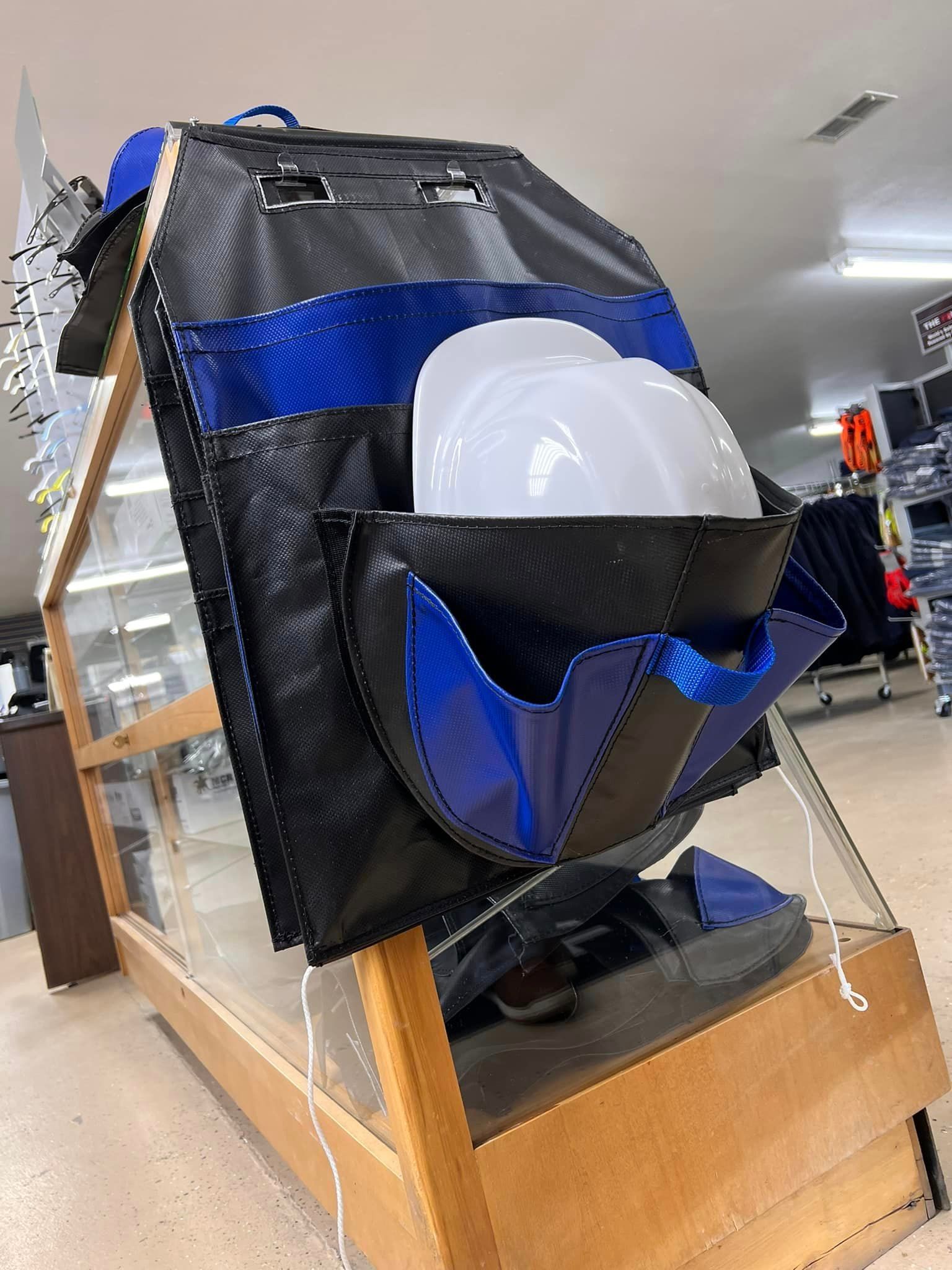 Black-and-blue display bag with a clear dome-like object on a wooden stand indoors
