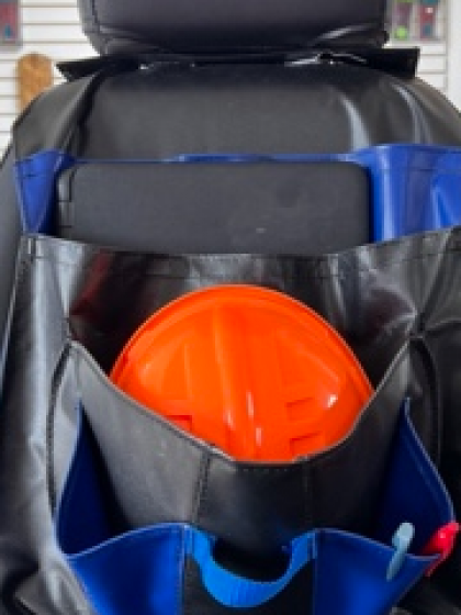 Black-and-blue seat-back organizer holding an orange hard hat in the front pocket