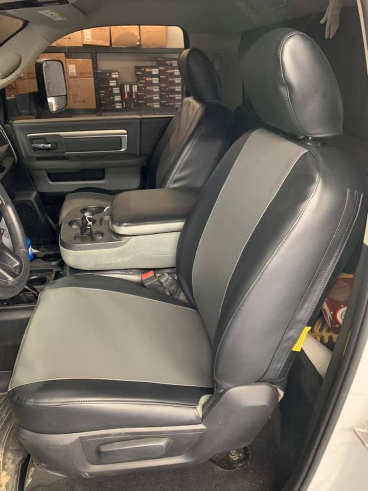 Front passenger seat and center console of a black car interior, with the door open.