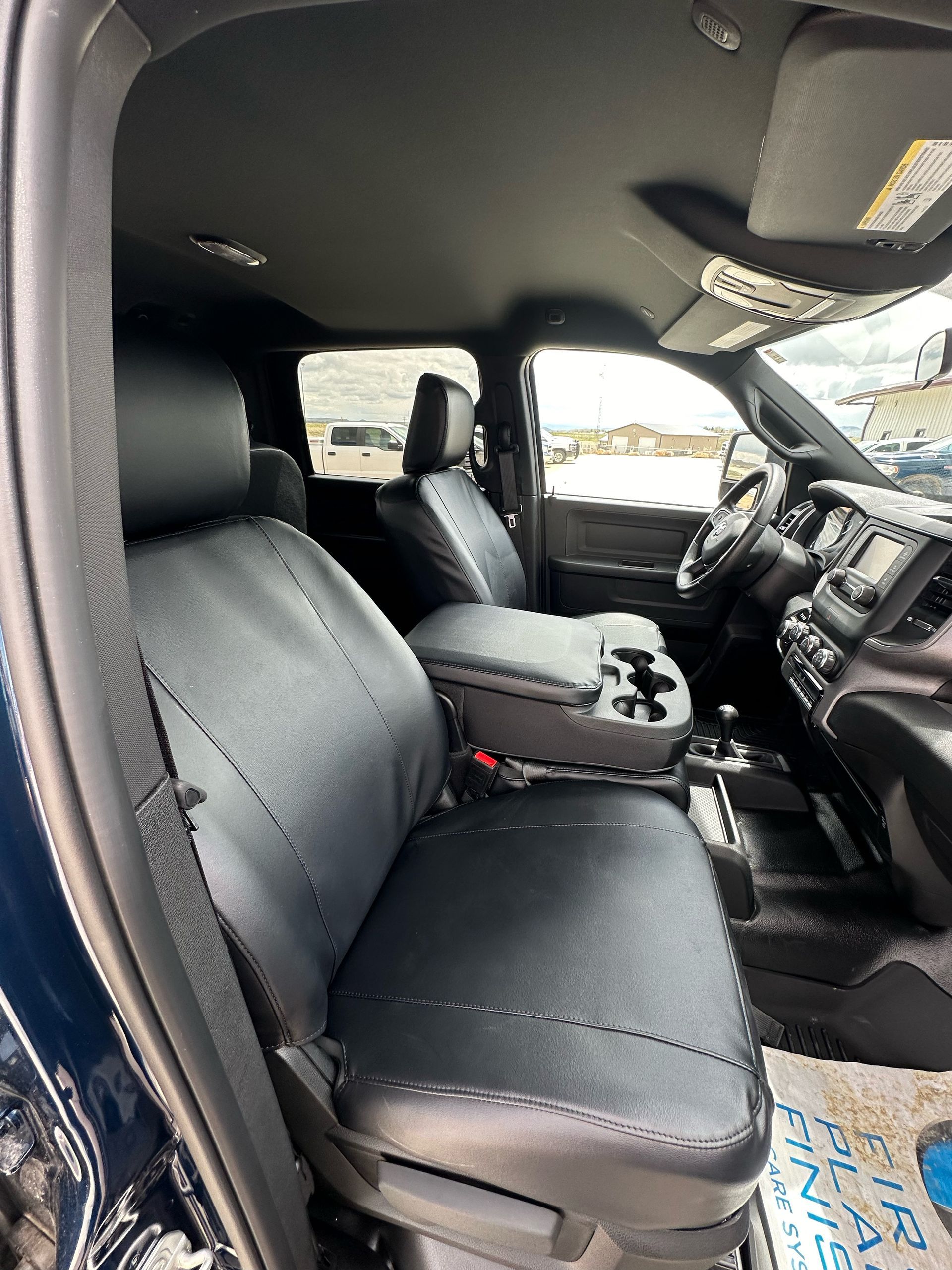 Truck cab interior with black seats and center console, viewed from the passenger side