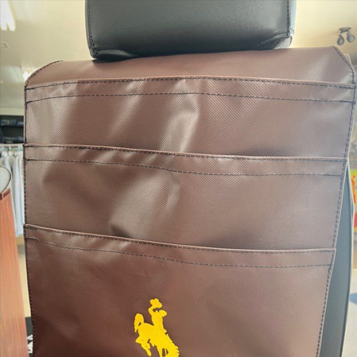 Brown leather seat cover with a yellow horse logo on the backrest