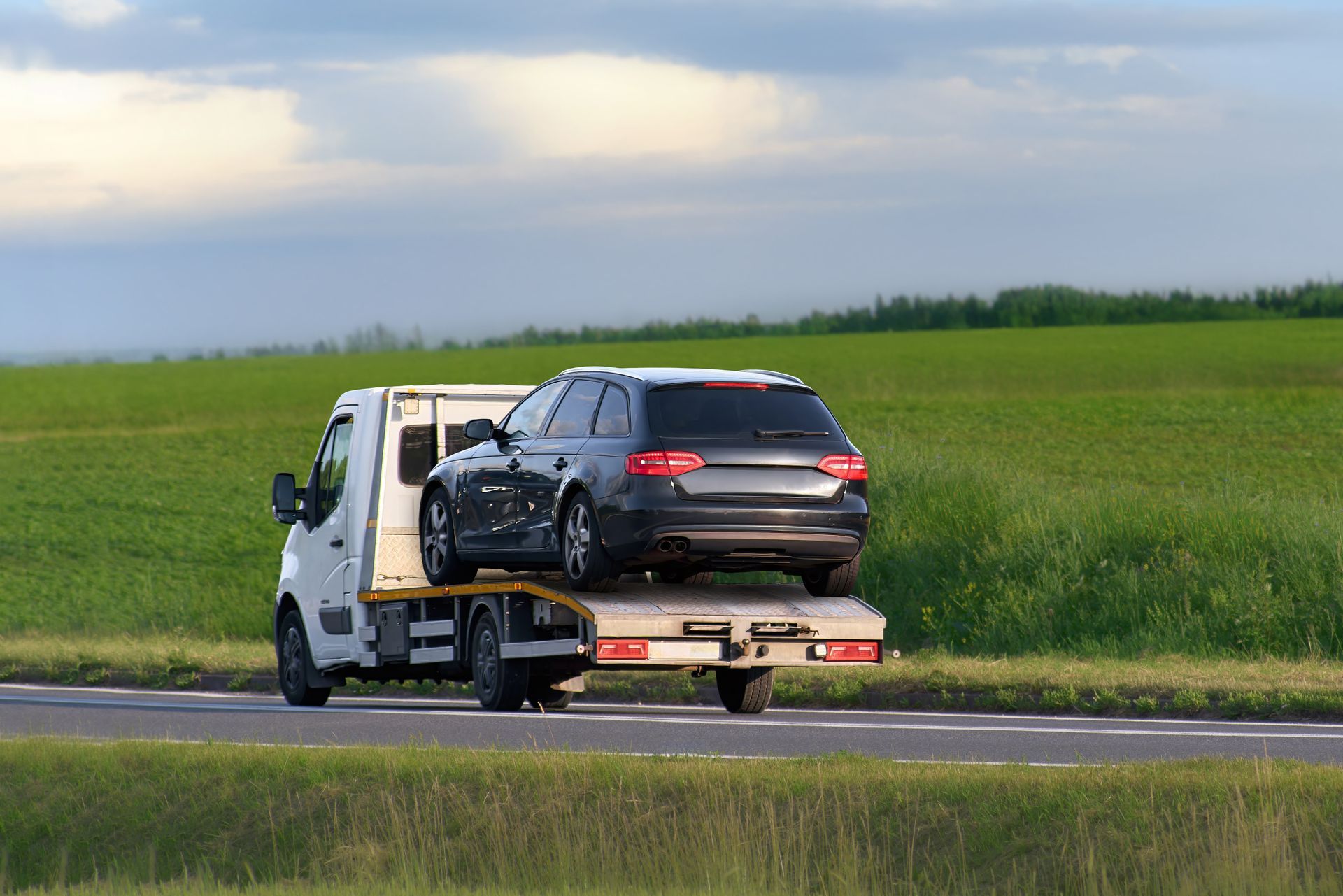 Car being towed by roadside assistance vehicle.