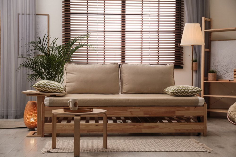 A Living Room With a Couch, Table, Lamp and Window Blinds — TT Shutters & Shading In Kingscliff, NSW