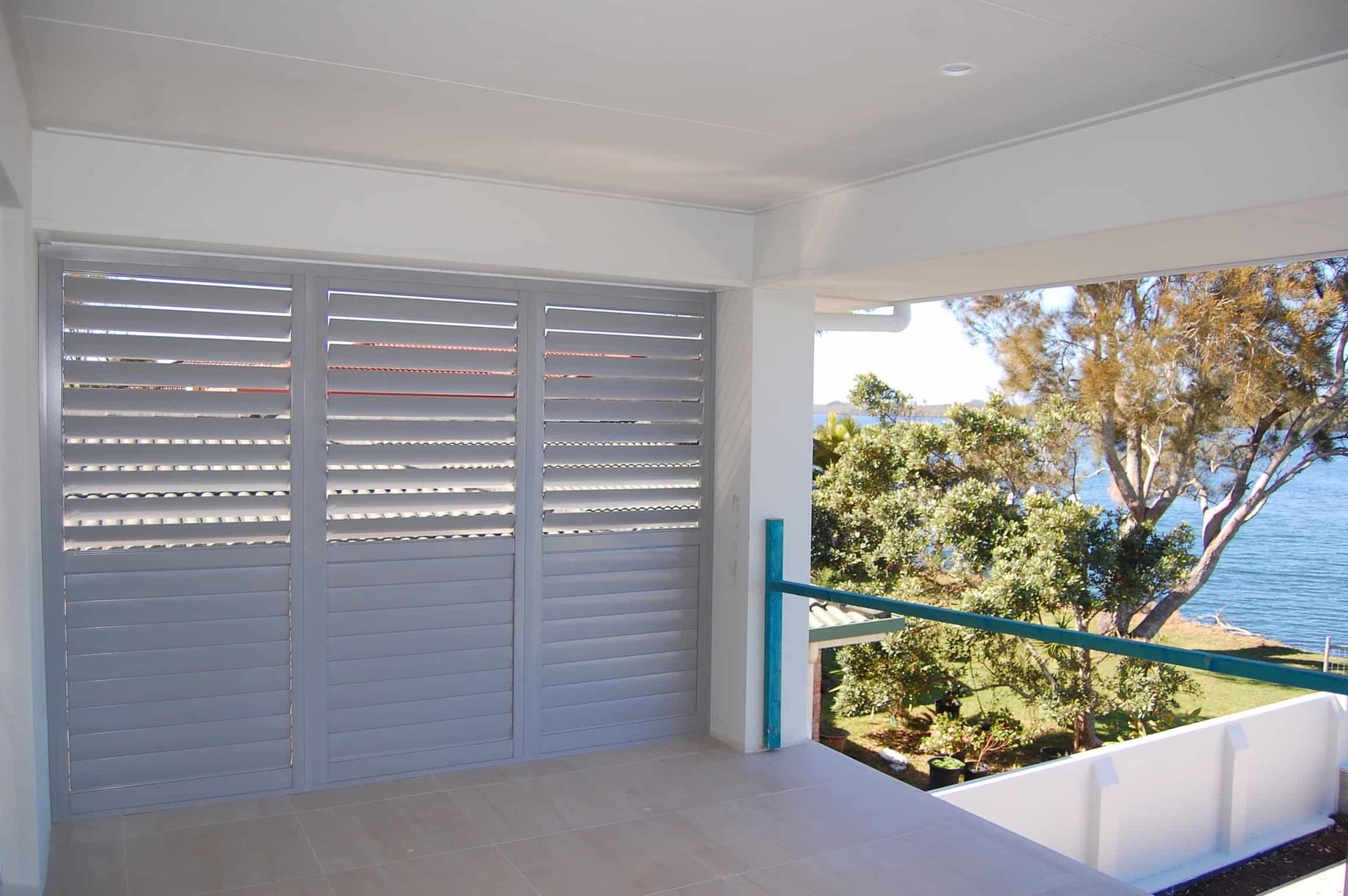 A Balcony With a View of the Ocean and Trees — TT Shutters & Shading In Ballina, NSW