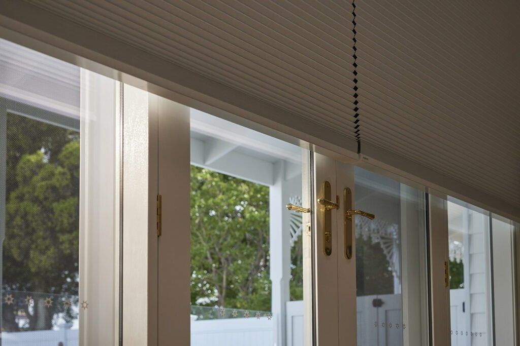 A Room With a Lot of Windows and a Cross Hanging From the Ceiling — TT Shutters & Shading In Ballina, NSW