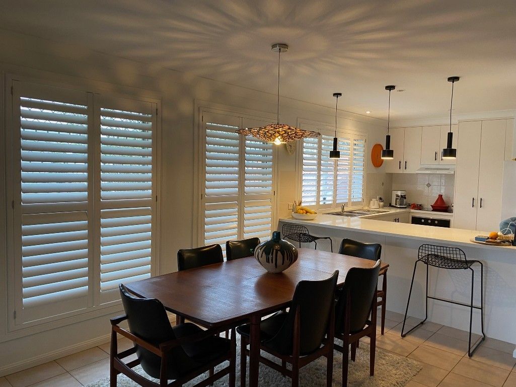 A Room With A Table And Chairs And Shutters On The Windows — TT Shutters & Shading In Ballina, NSW