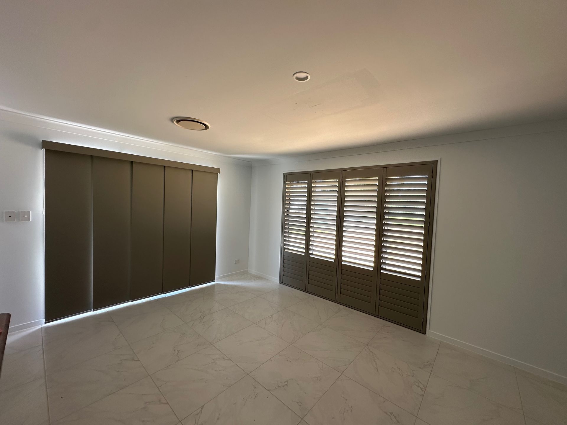 An Empty Room With Shutters on the Windows and a Ceiling Light — TT Shutters & Shading In Ballina, NSW