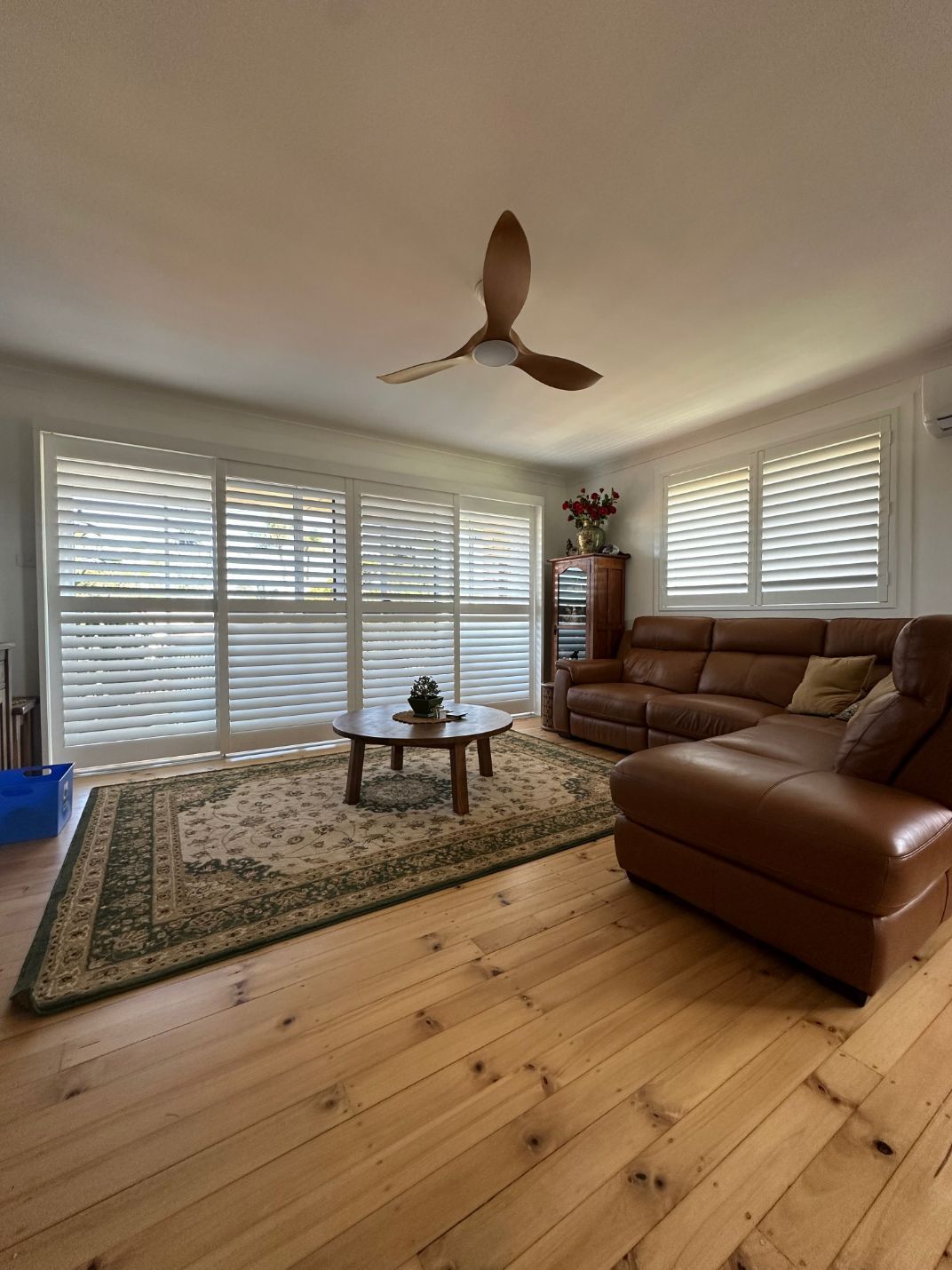A Living Room With A Couch, Coffee Table, And Ceiling Fan — TT Shutters & Shading In Ballina, NSW