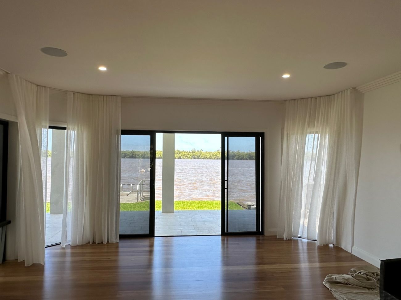A Living Room With Curtains And A Sliding Glass Door — TT Shutters & Shading In Ballina, NSW