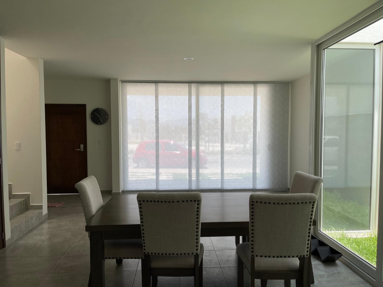 A Dining Room With a Table and Chairs and a Large Window — TT Shutters & Shading In Evans Head, NSW