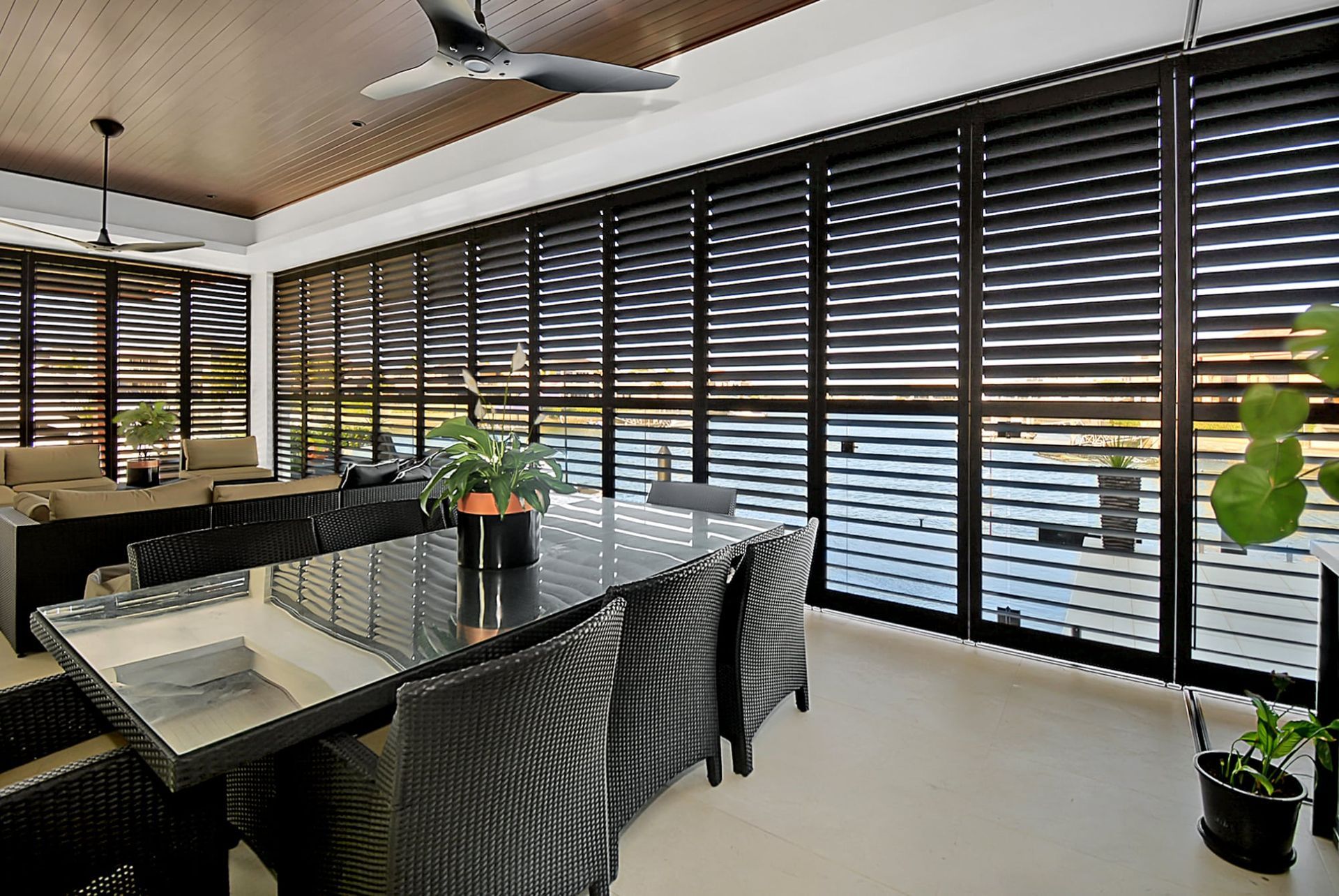 A Dining Room With a Table and Chairs and a Ceiling Fan — TT Shutters & Shading In Ballina, NSW
