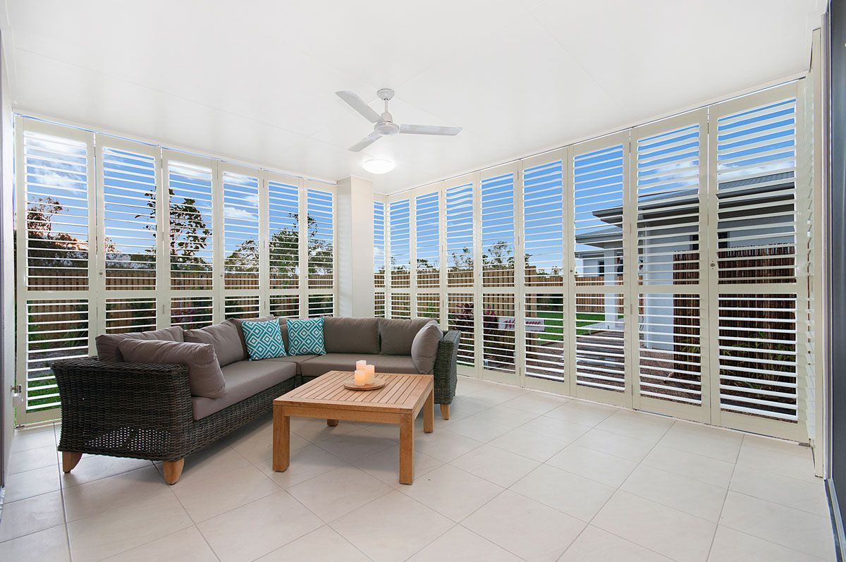 A Living Room With a Couch and Shutters on the Windows — TT Shutters & Shading In Ballina, NSW