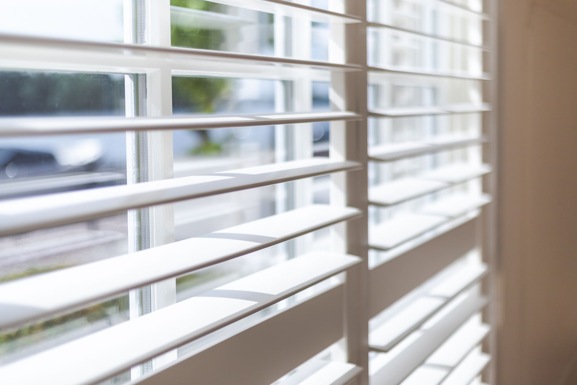 A Close Up of a Window With White Shutters on It — TT Shutters & Shading In Ballina, NSW