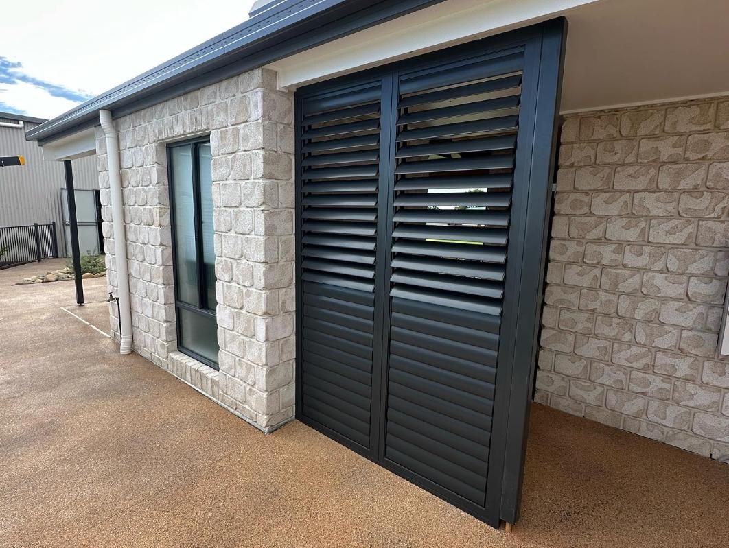 A House With a Window and Shutters on the Side of It — TT Shutters & Shading In Ballina, NSW
