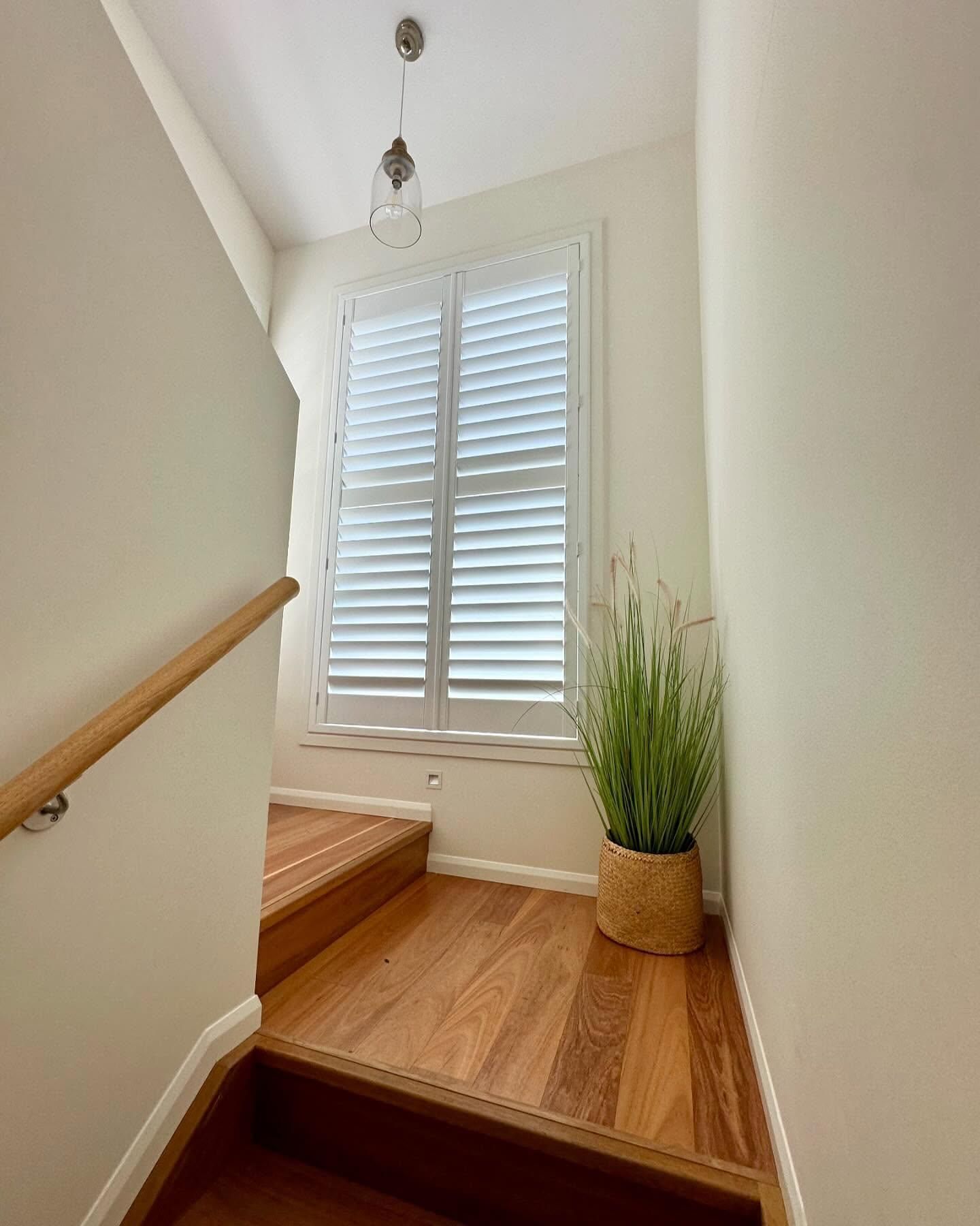 A Staircase With Wooden Steps and a Window With Shutters — TT Shutters & Shading In Evans Head, NSW