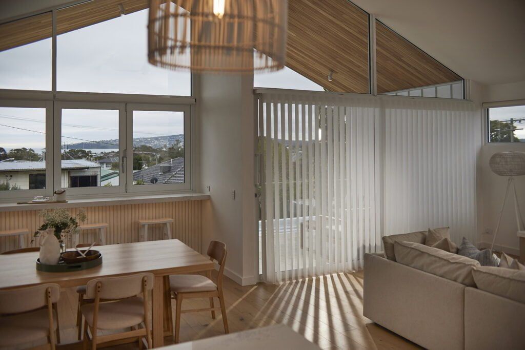 A Living Room With a Dining Table and Chairs and a Couch — TT Shutters & Shading In Ballina, NSW