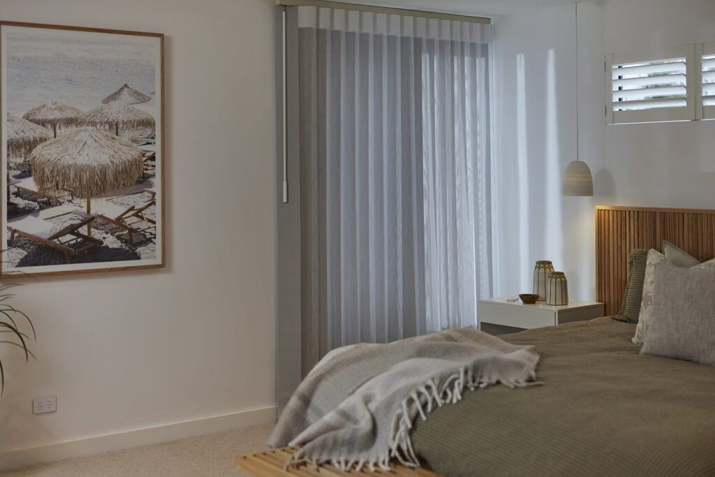 A Bedroom With a Bed and a Painting on the Wall — TT Shutters & Shading In Ballina, NSW
