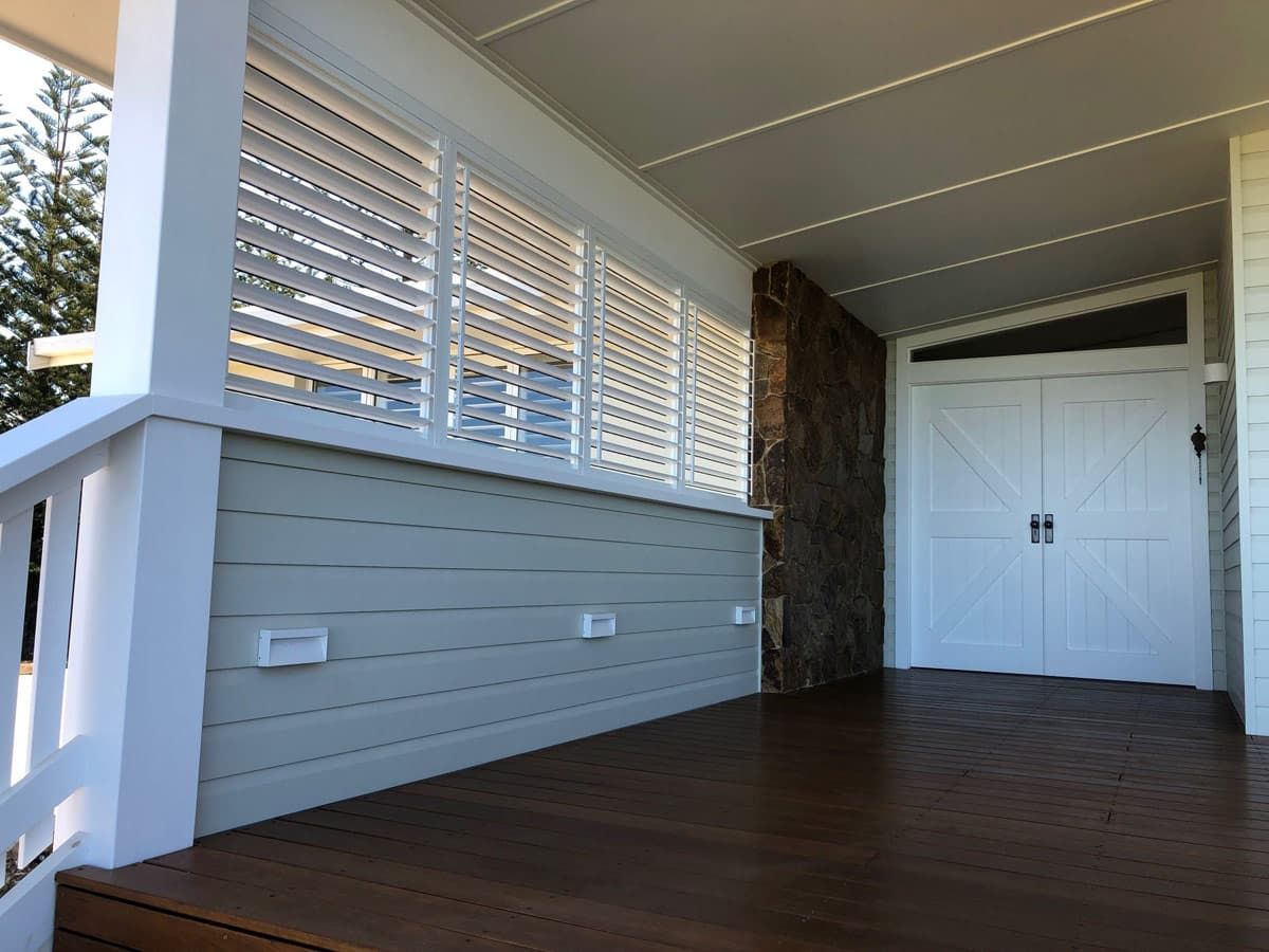 A Porch With White Shutters and a Wooden Floor — TT Shutters & Shading In Ballina, NSW