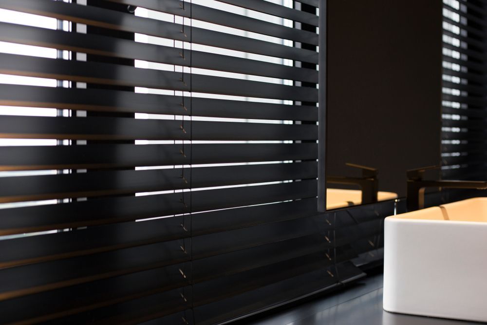 A Bathroom With Black Blinds and a White Sink — TT Shutters & Shading In Pottsville, NSW