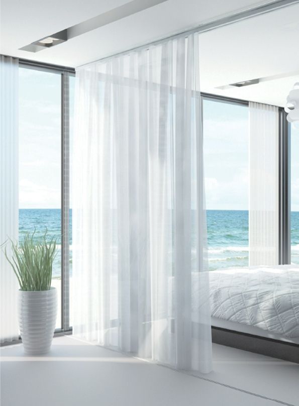 A Bedroom With White Curtains and a View of the Ocean — TT Shutters & Shading In Tweed Heads, NSW