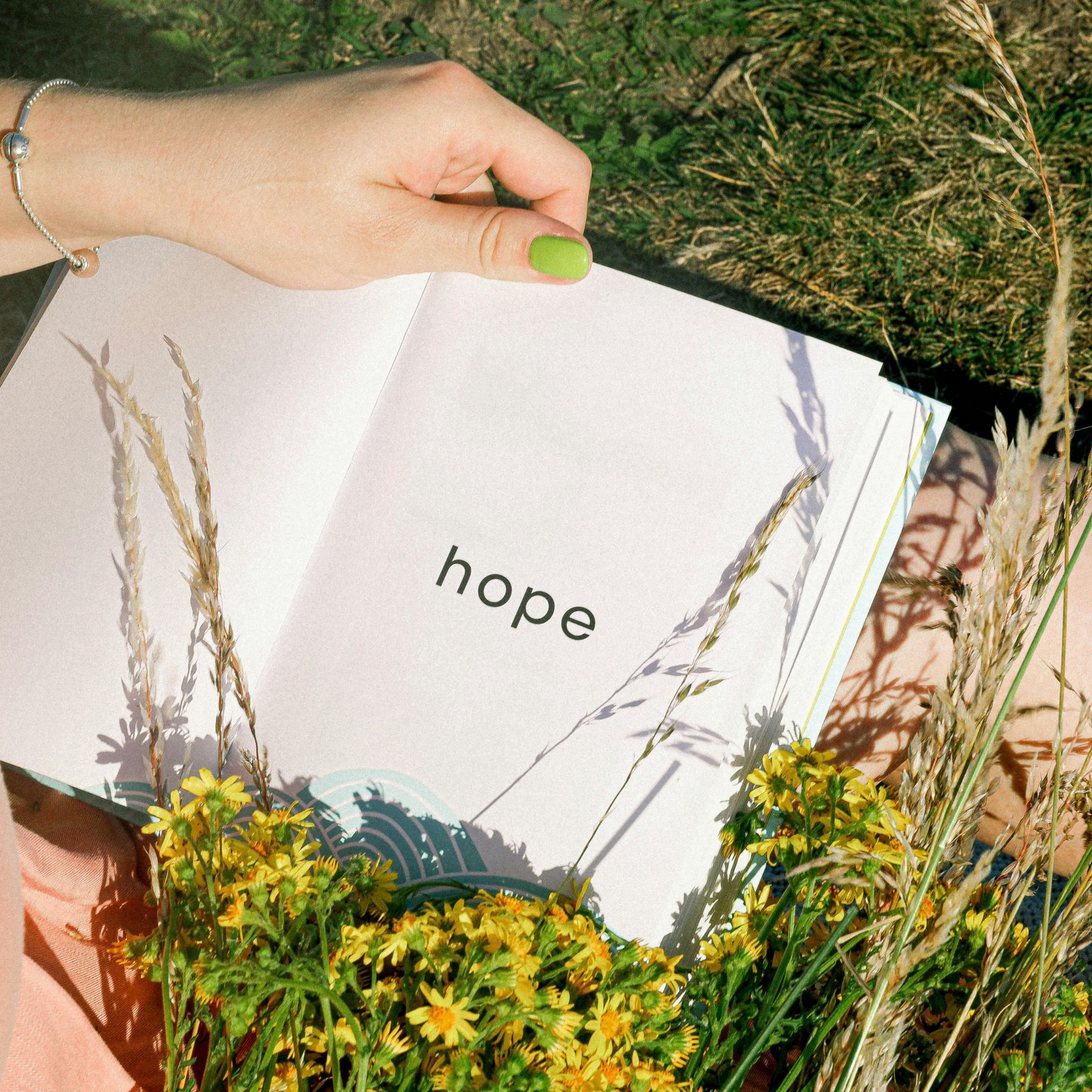 A person holds an open book displaying the word 