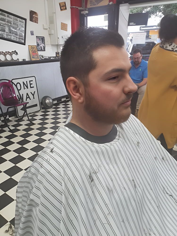 A Man Is Getting His Hair And Beard Cut At A Barber Shop — The Barber Social In Raymond Terrace, NSW