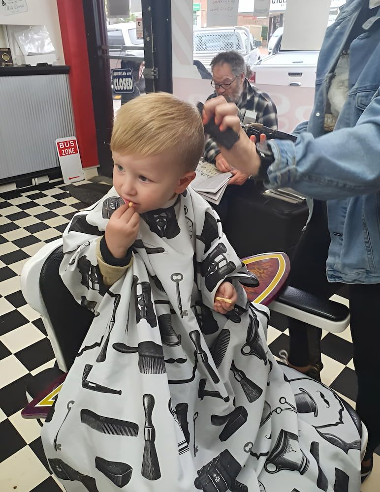 A Little Boy Is Getting His Hair Cut At A Barber Shop — The Barber Social In Raymond Terrace, NSW