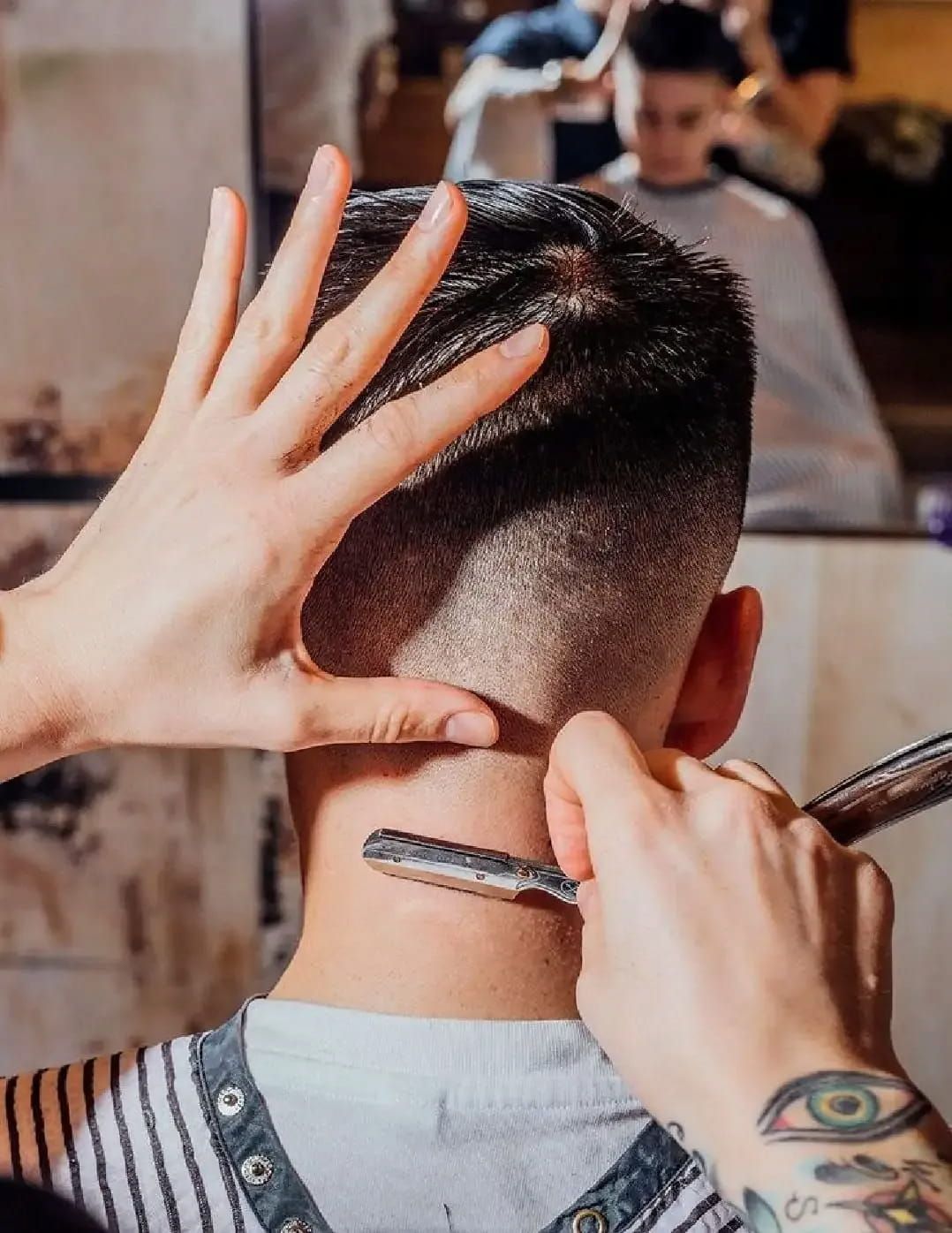 A Man Is Getting His Hair Cut By A Barber With A Razor — The Barber Social In Raymond Terrace, NSW