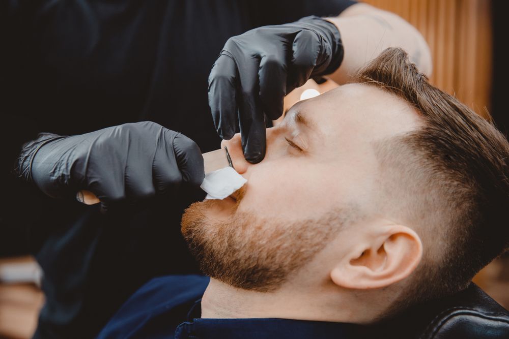 A Person Uses a Wax Strip to Remove Hair in A Professional Salon Setting — The Barber Social In Raymond Terrace, NSW