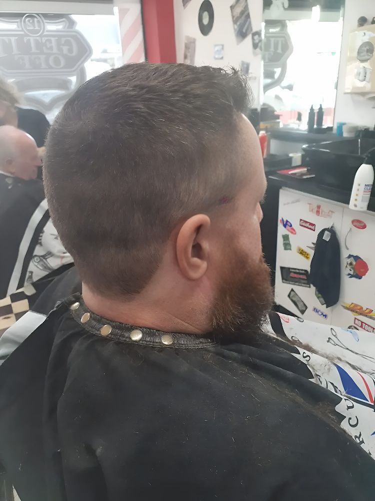 A Man With A Beard Is Getting His Hair Cut At A Barber Shop — The Barber Social In Raymond Terrace, NSW