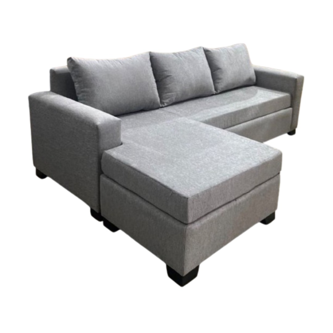 Un sofá modular azul con dos cojines decorativos de color beige