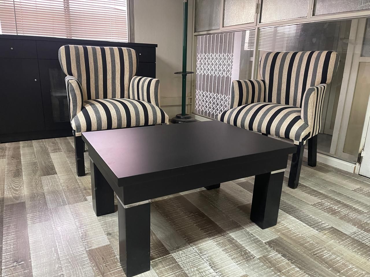Dos sillones a rayas se encuentran frente a una mesa de centro