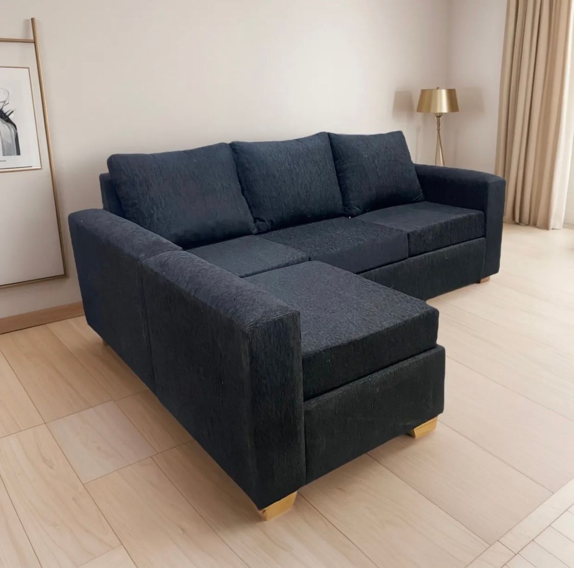Un sofá modular gris oscuro con patas de madera