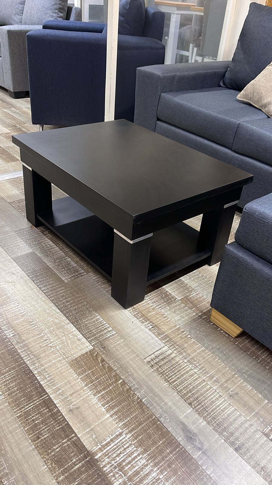 Una mesa de centro rectangular blanca con un estante inferior