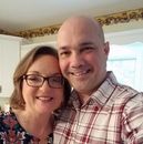A man and a woman are posing for a selfie in a kitchen.