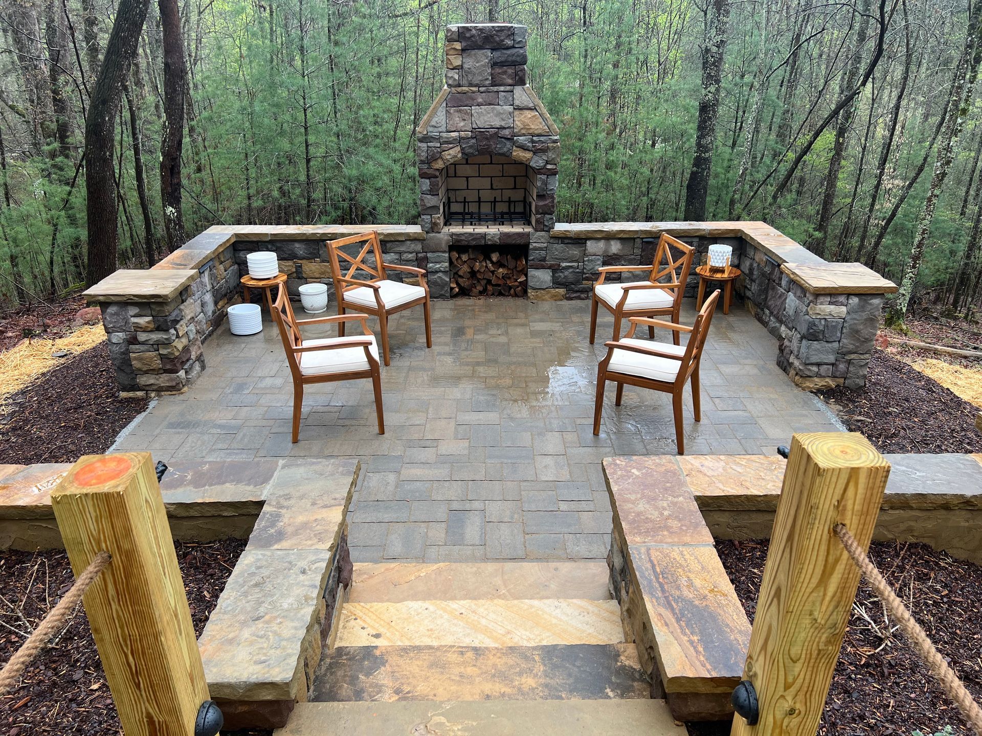 A patio with chairs and a fireplace in the middle