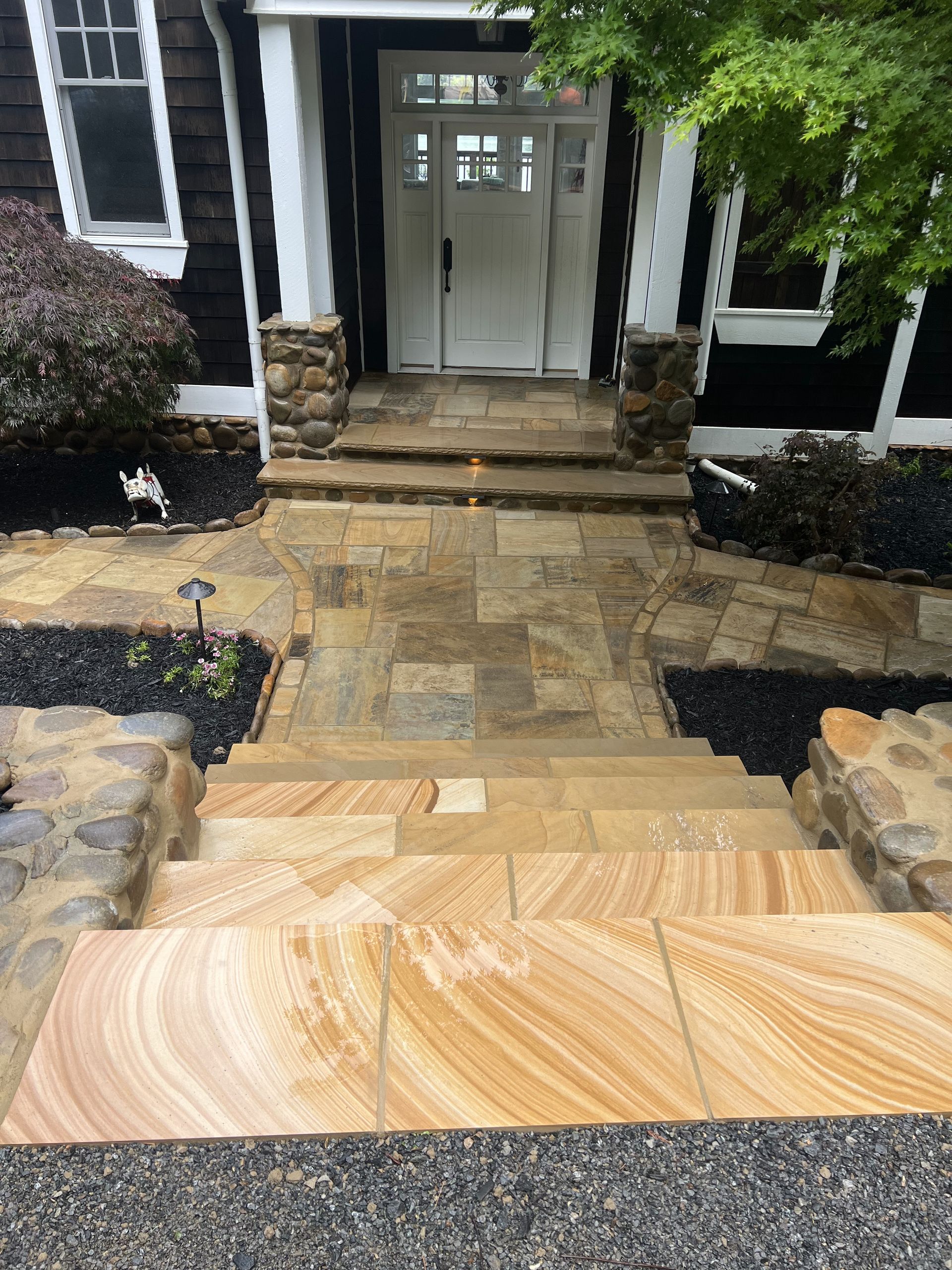 A stone walkway leading to the front door of a house
