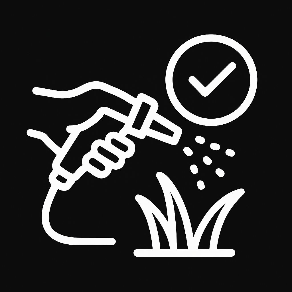 A hand is spraying grass with a hose.