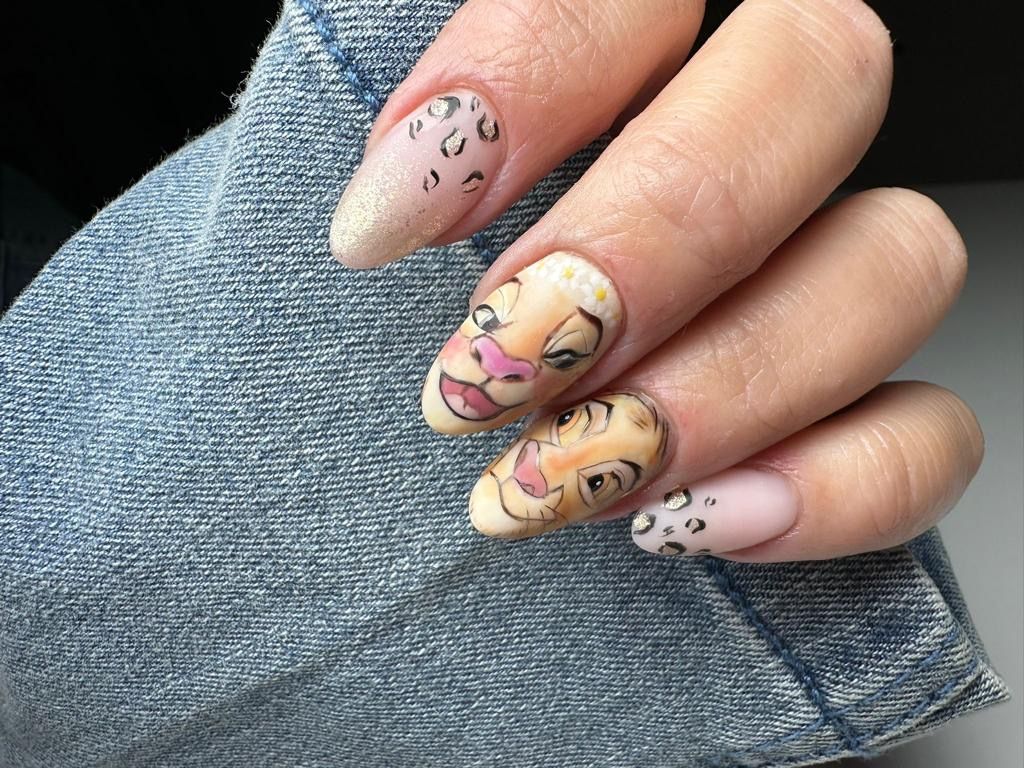 le unghie di una donna sono decorate con un disegno del re leone .