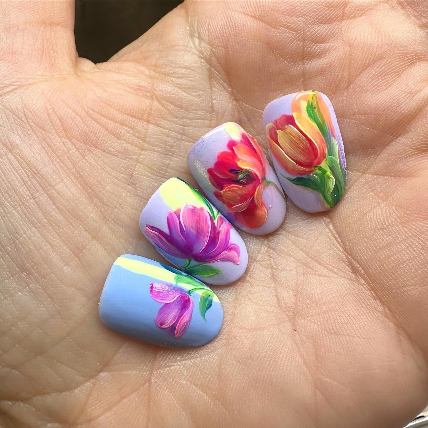 una donna tiene in mano un foglio di carta con le unghie rosa e bianche .