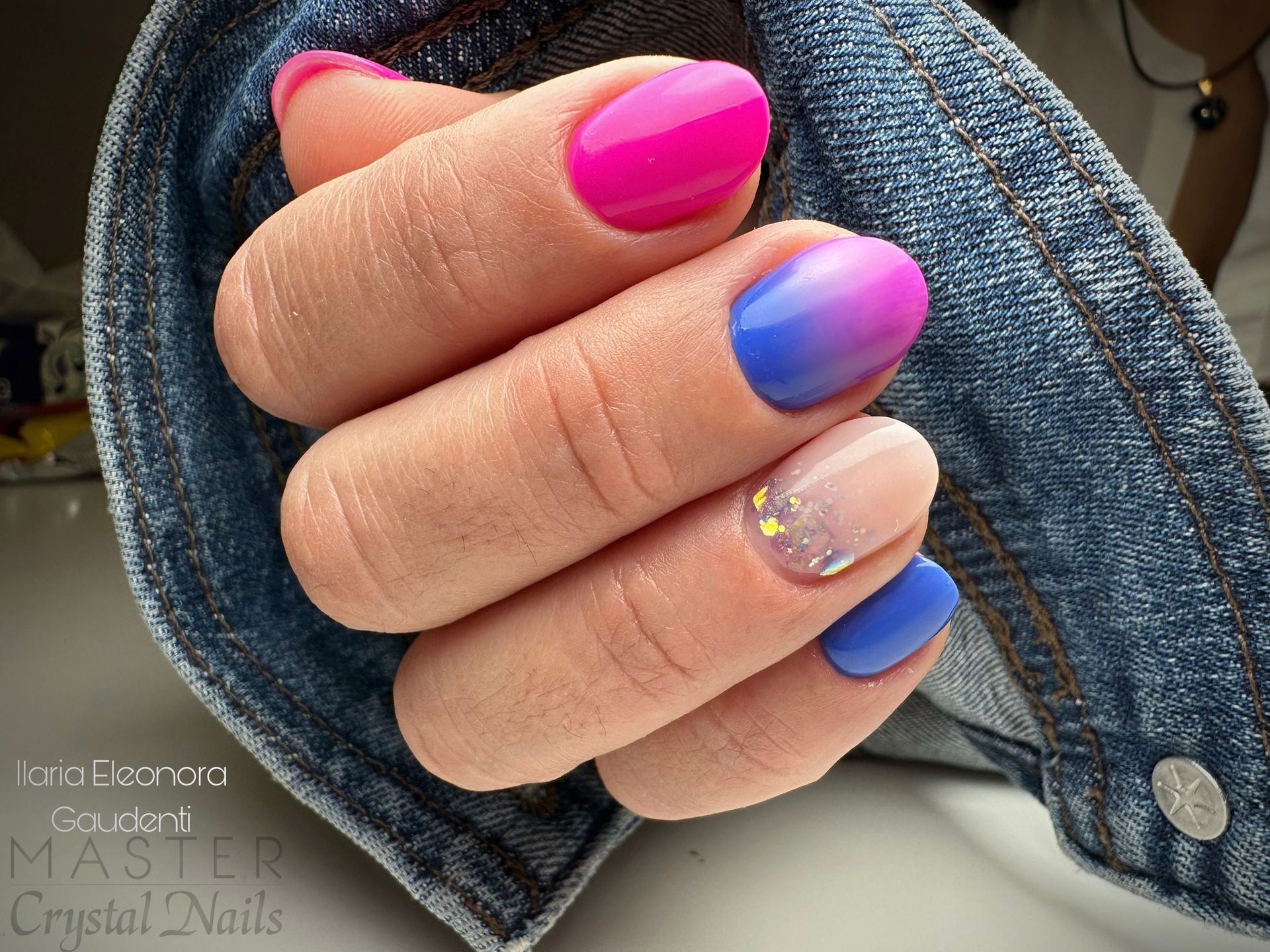 una donna tiene in mano un paio di unghie rosa e blu .