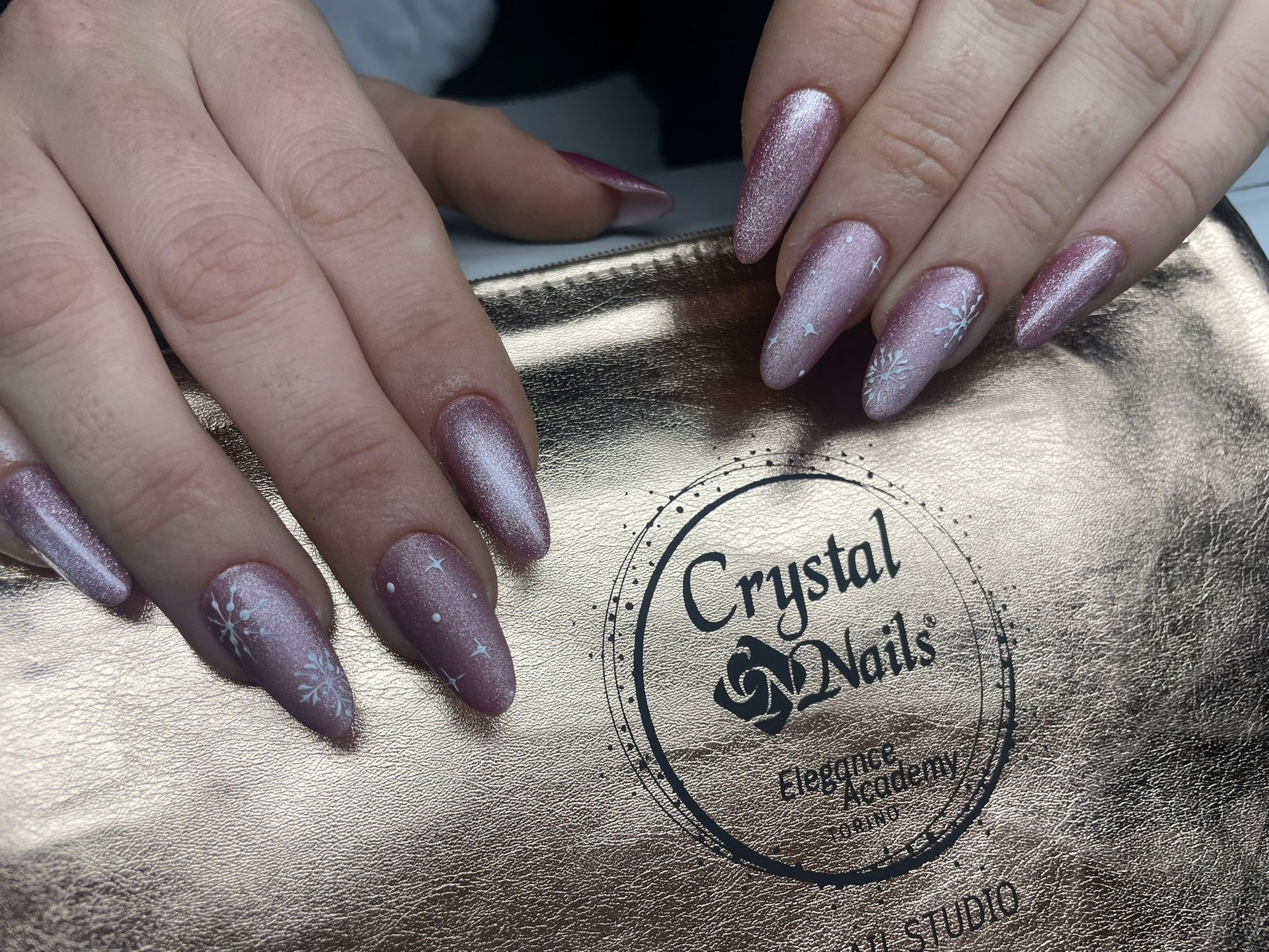 un primo piano di una donna 's mani con unghie rosa e un logo di cristal nails