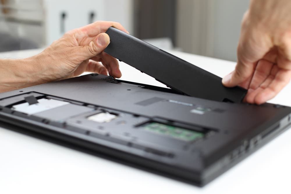 A Person is Taking the Battery Out of a Laptop Computer — Leading Edge Computers in Forster, NSW