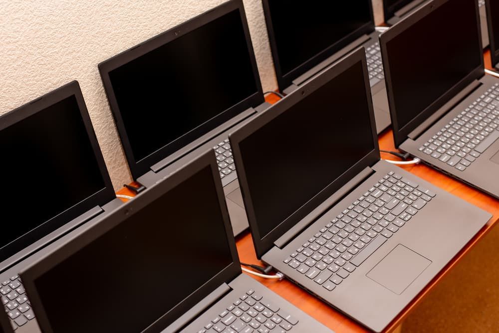 A Row of Laptops Are Lined Up on a Wooden Table — Leading Edge Computers in Forster, NSW