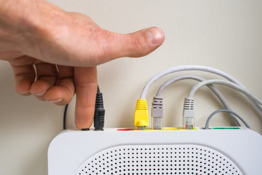 A Person is Plugging a Cable Into a Router — Leading Edge Computers in Forster, NSW