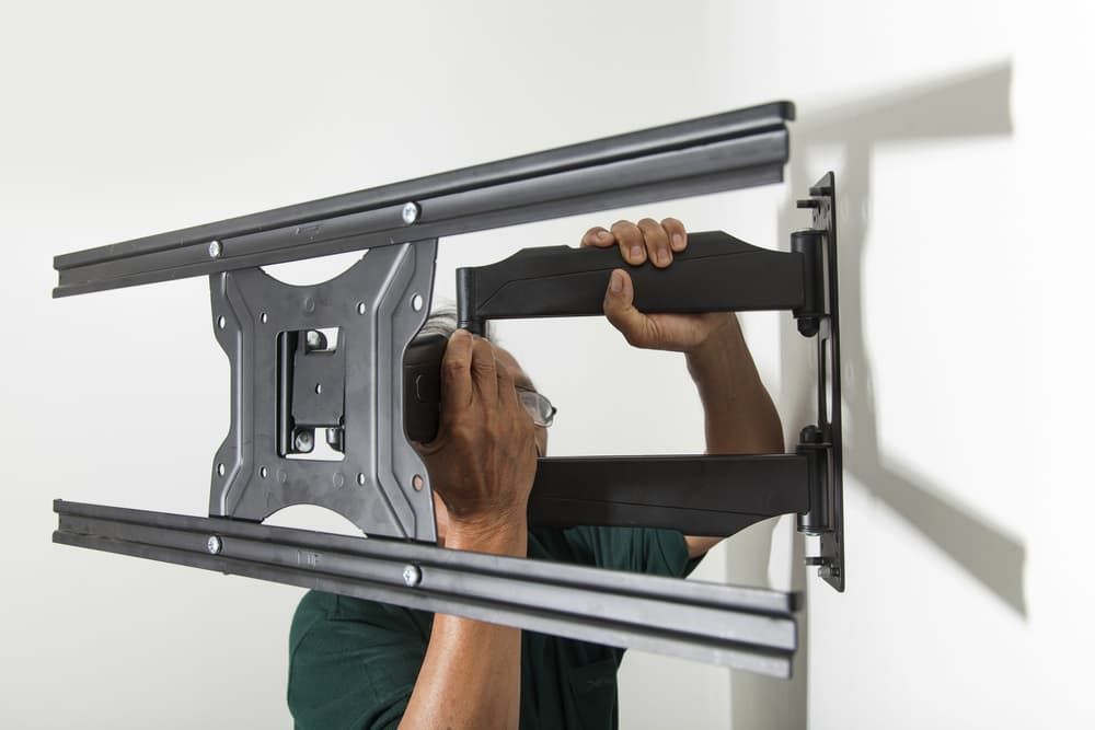 A Man is Installing a Tv Mount on a Wall — Leading Edge Computers in Forster, NSW