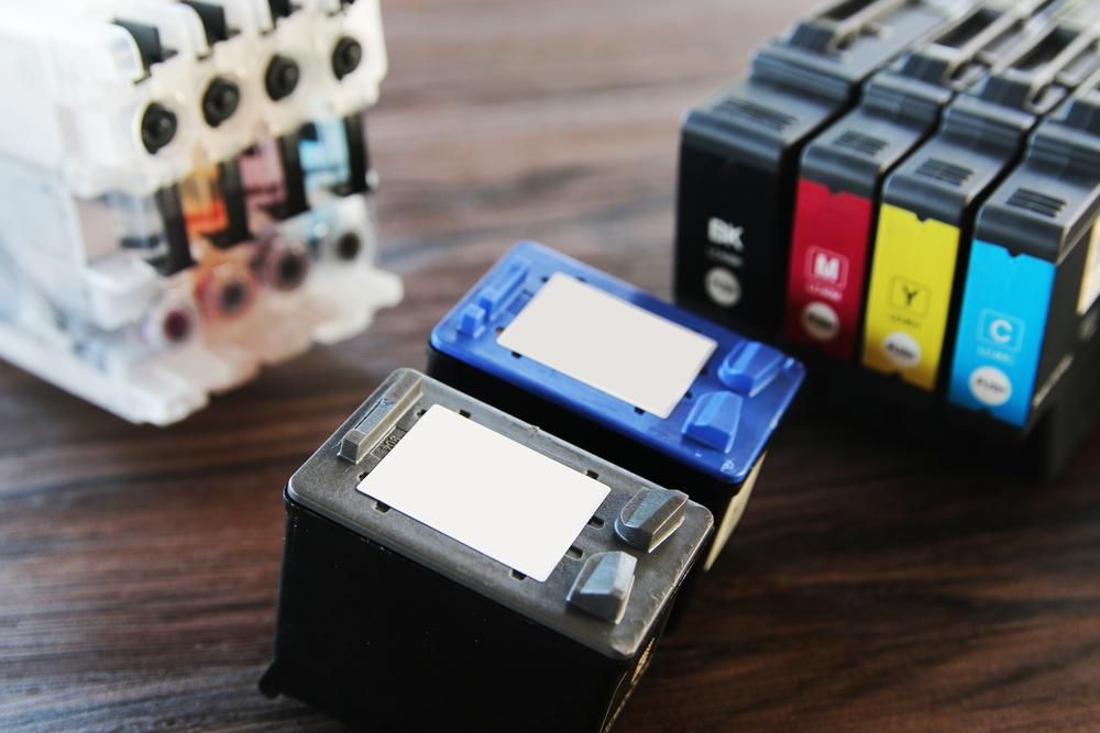 A Bunch of Ink Cartridges Are Sitting on a Wooden Table — Leading Edge Computers in Forster, NSW
